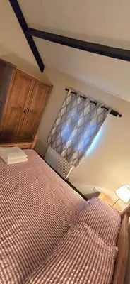 a bedroom with a bed and a window at Charming Coach House Cottage in Brentwood in Kelvedon Hatch