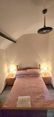 a bedroom with a bed with two lamps on both sides at Charming Coach House Cottage in Brentwood in Kelvedon Hatch
