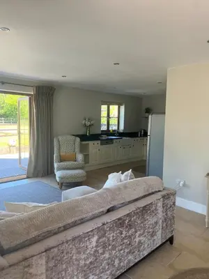 a living room with a couch and a kitchen at Cottage nestled in the heart of a stunning Suffolk Village in Chediston