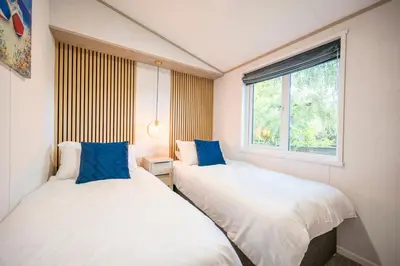 two beds in a small room with a window at The Cabin, Ufford in Ufford