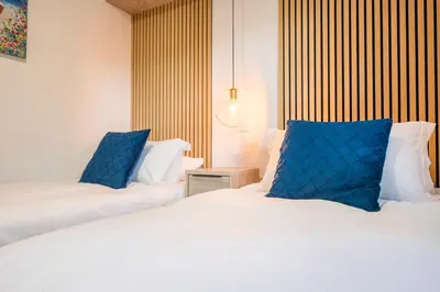 two beds in a hotel room with blue pillows at The Cabin, Ufford in Ufford