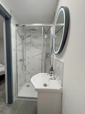 a bathroom with a shower and a sink and a mirror at 4 Bed Home In Central Maldon in Maldon