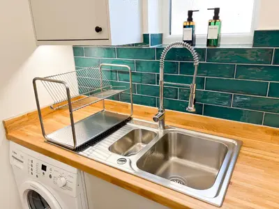 a kitchen sink with a dish drying rack next to it at 4 Bed Home In Central Maldon in Maldon