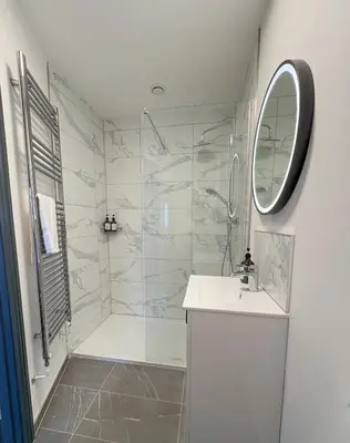 a bathroom with a shower and a sink and a mirror at 4 Bed Home In Central Maldon in Maldon