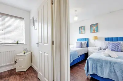 a white bedroom with two beds and a window at Modern 3-Bed 3-Bath Home - Quiet Road - Parking For 2 Cars - LMV Property in Great Burstead