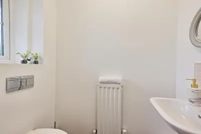 a white bathroom with a toilet and a sink at Modern 3-Bed 3-Bath Home - Quiet Road - Parking For 2 Cars - LMV Property in Great Burstead