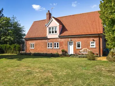 a brick house with a red roof and a yard at Green Farm Cottage in Redgrave