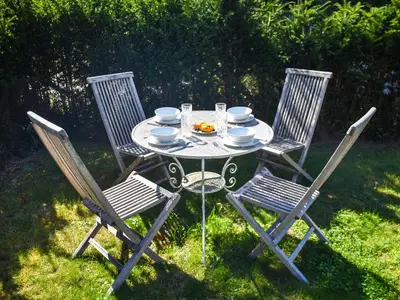 a table and four chairs with a tea set on it at Green Farm Cottage in Redgrave