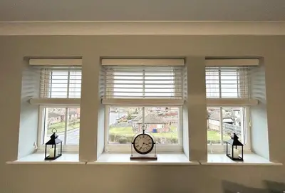 a room with three windows with a clock and lights at Apartment I Sleeps 4 I Wi-Fi I Parking I Rail Links I Newmarket in Newmarket