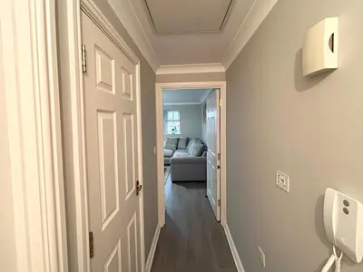 a hallway with a door and a couch in a room at Apartment I Sleeps 4 I Wi-Fi I Parking I Rail Links I Newmarket in Newmarket