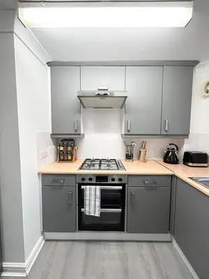 a kitchen with gray cabinets and a stove top oven at Apartment I Sleeps 4 I Wi-Fi I Parking I Rail Links I Newmarket in Newmarket