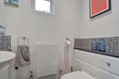 a white bathroom with a toilet and a sink at Spacious 4 bedroom house in Bishop's Stortford in Thorley