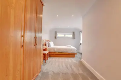 a bedroom with a bed and a window at Spacious 4 bedroom house in Bishop's Stortford in Thorley