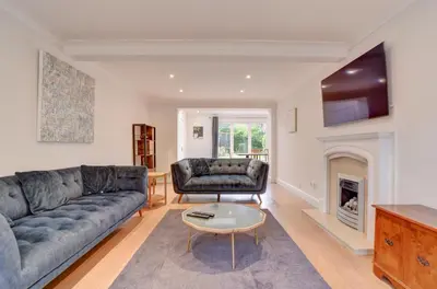 a living room with a couch and a fireplace at Spacious 4 bedroom house in Bishop's Stortford in Thorley