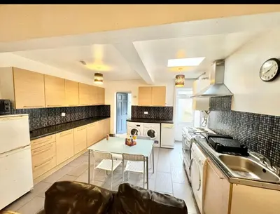 a large kitchen with a table and chairs in it at Karan Lodge in Mildenhall