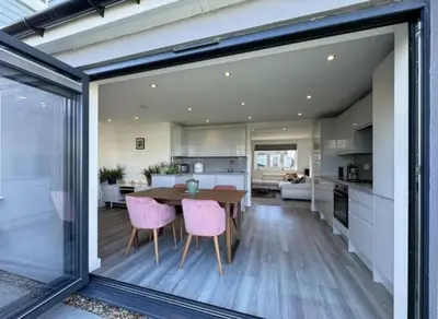 a kitchen and dining room with a table and chairs at The Larks Spacious 3BR Essex in Vange
