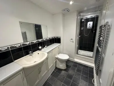 a white bathroom with a sink and a toilet at Ely Stays Flat 2 in Ely