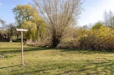 a wooden sign in the middle of a field at Spacious Riverside View Bungalow in Chelmsford