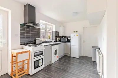 a kitchen with a stove and a white refrigerator at Spacious Riverside View Bungalow in Chelmsford
