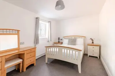 a bedroom with a bed and a desk and a bed sidx sidx sidx at Spacious Riverside View Bungalow in Chelmsford