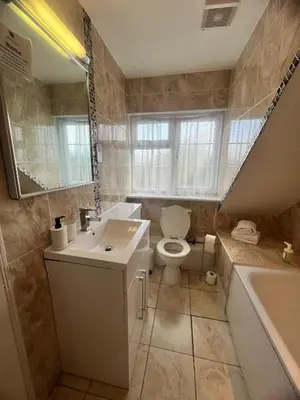 a bathroom with a toilet and a sink and a tub at Rivenhall Garden Hotel in Rivenhall