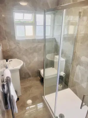 a bathroom with a shower and a toilet and a sink at Rivenhall Garden Hotel in Rivenhall