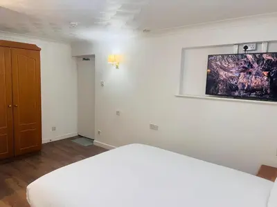 a bedroom with a bed and a painting on the wall at Rivenhall Garden Hotel in Rivenhall