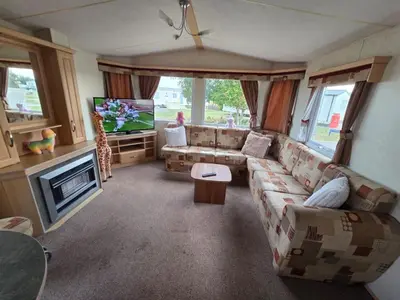 a living room with a couch and a tv at St Osyth, Clacton-on-sea, Cozy Beach side Caravan, Wifi, Tea and Coffee, Parking included in Saint Osyth