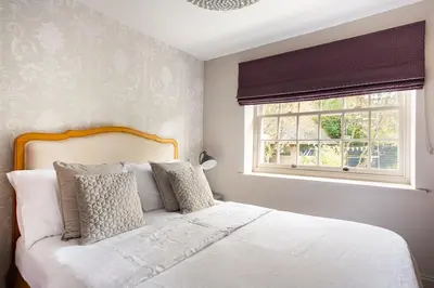 a bedroom with a white bed with a window at Cosy Barn Conversion - peaceful, private double room in Shenfield