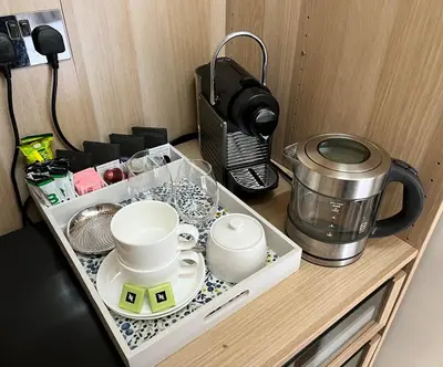 a tray with cups and dishes on a kitchen counter at Cosy Barn Conversion - peaceful, private double room in Shenfield