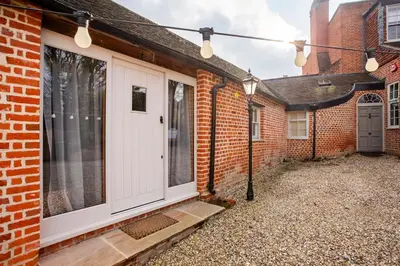 a front door of a brick house with lights at Cosy Barn Conversion - peaceful, private double room in Shenfield