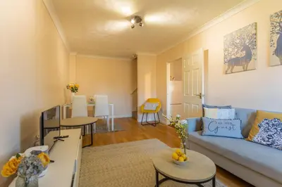 a living room with a blue couch and tables at K Suites - Tollgate Court in Colchester