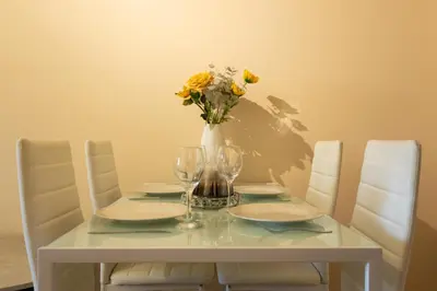 a white table with a vase of flowers on it at K Suites - Tollgate Court in Colchester