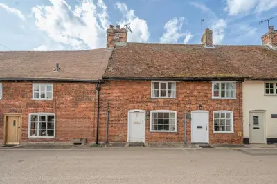 a brick house with four doors and a roof at Charming 2BR Cottage in Orford