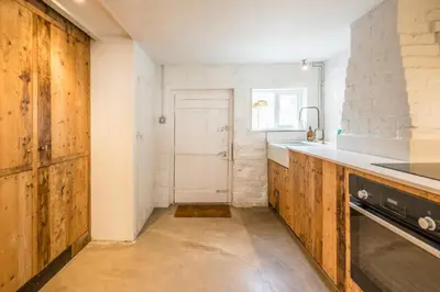 a kitchen with wooden cabinets and a sink at Charming 2BR Cottage in Orford