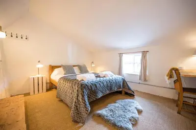a bedroom with a bed and a window at Charming 2BR Cottage in Orford