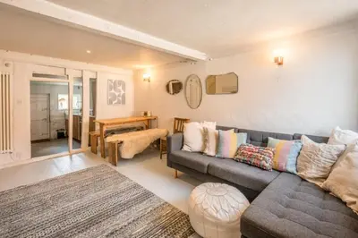 a living room with a couch and a table at Charming 2BR Cottage in Orford