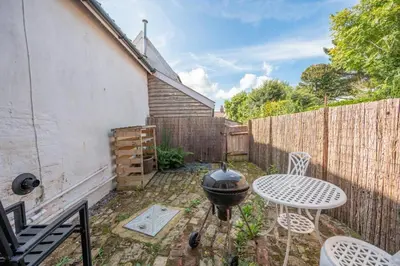a backyard with a grill and a table and chairs at Charming 2BR Cottage in Orford