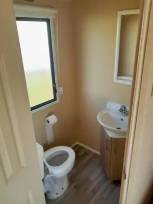 a bathroom with a toilet and a sink at Comfortable and Spacious Mobile home - Sleeps 6, in Clacton-on-Sea