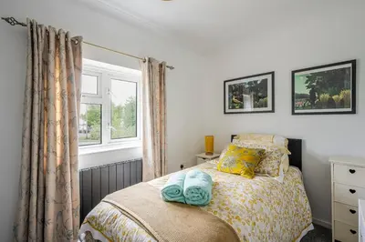 a bedroom with a bed and a window at Rosabelle in Wivenhoe