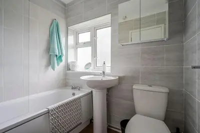 a bathroom with a toilet and a sink and a tub at Rosabelle in Wivenhoe