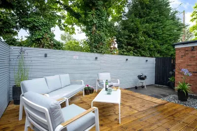 a patio with a couch and chairs on a wooden deck at Detached House in Quiet Village - Pets Allowed in Ipswich