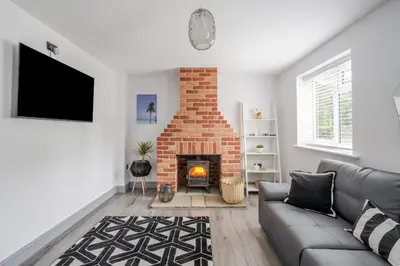 a living room with a brick fireplace and a couch at Detached House in Quiet Village - Pets Allowed in Ipswich