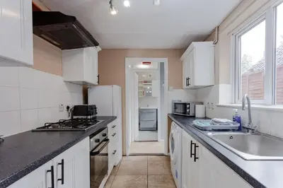 a kitchen with a sink and a refrigerator at ML Short Stays - 3 bed contractor house near Sizewell C in Leiston