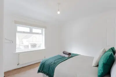 a white bedroom with a bed and a window at ML Short Stays - 3 bed contractor house near Sizewell C in Leiston