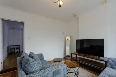 a living room with two couches and a flat screen tv at ML Short Stays - 3 bed contractor house near Sizewell C in Leiston