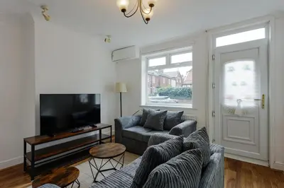 a living room with a couch and a tv at ML Short Stays - 3 bed contractor house near Sizewell C in Leiston