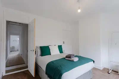 a bedroom with a bed with a green and white blanket at ML Short Stays - 3 bed contractor house near Sizewell C in Leiston