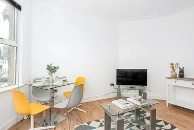 a living room with a table and chairs and a television at Modern 3 Bedroom Home with Parking in Southend in Southend-on-Sea