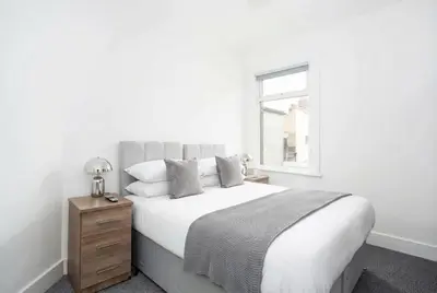 a white bedroom with a large bed and a window at Modern 3 Bedroom Home with Parking in Southend in Southend-on-Sea